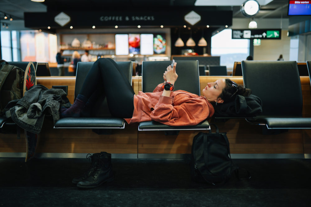 mujer_esperando_en_aeropuerto-1000x667 - ¿Cómo hacer que la clase turista sea una experiencia más agradable?