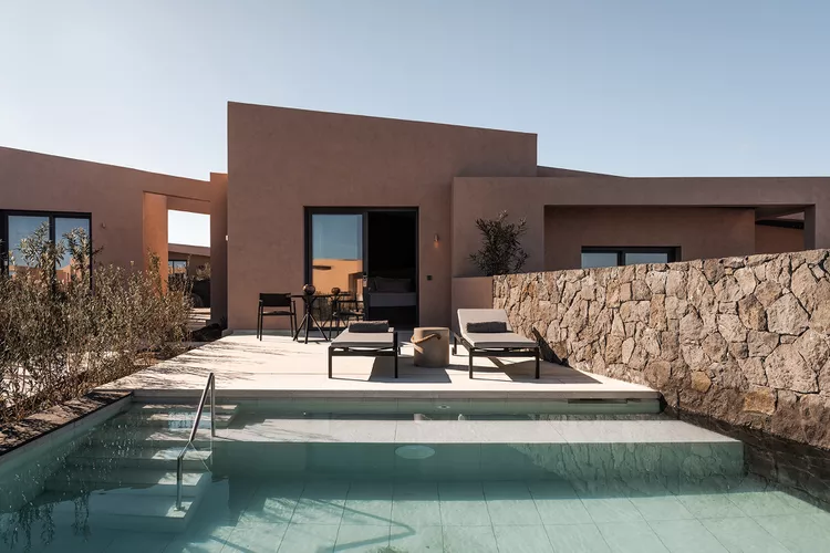 TAL-anesis-bungalow-exterior-domes-novos-santorini-DOMENOVOSJTR0524-8c21037fe8da429fa80ee2c49695ca7f-1 - Explorando el paraíso: este resort en Grecia tiene villas privadas y una gran psicina cubierta