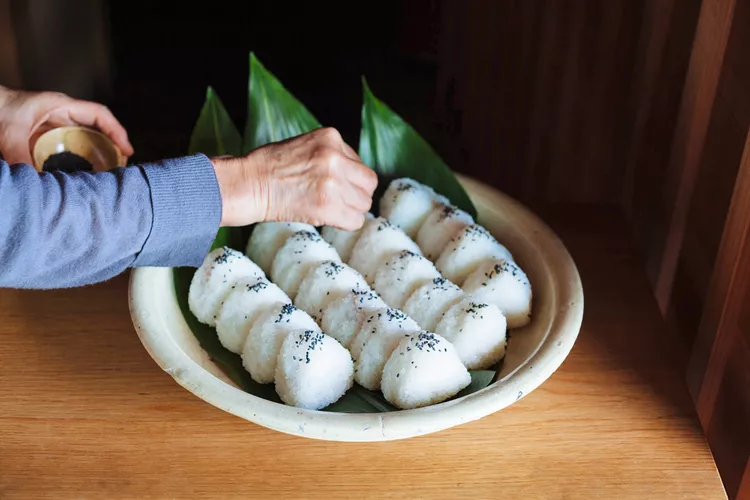 TAL-hands-rice-balls-bowl-KYUSHU1124-edbce112145c4bab9dc9f1b3dbd28d2f - Pasé 3 días pedaleando por Kyushu, Japón. Te cuento por qué es una manera increíble de conocer la isla.